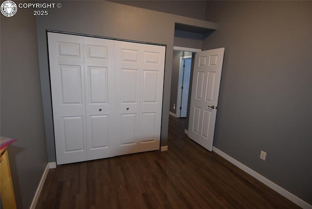 unfurnished bedroom with dark hardwood / wood-style floors and a closet