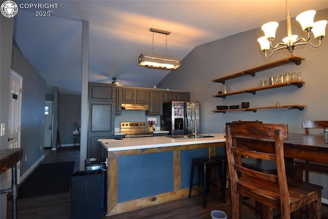 kitchen with pendant lighting, lofted ceiling, stainless steel appliances, and kitchen peninsula