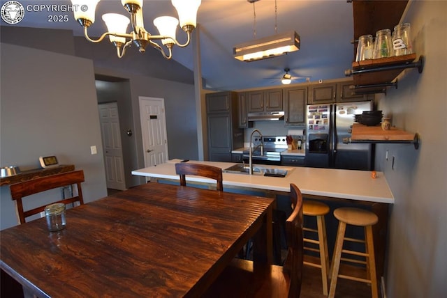 dining area featuring sink and ceiling fan with notable chandelier