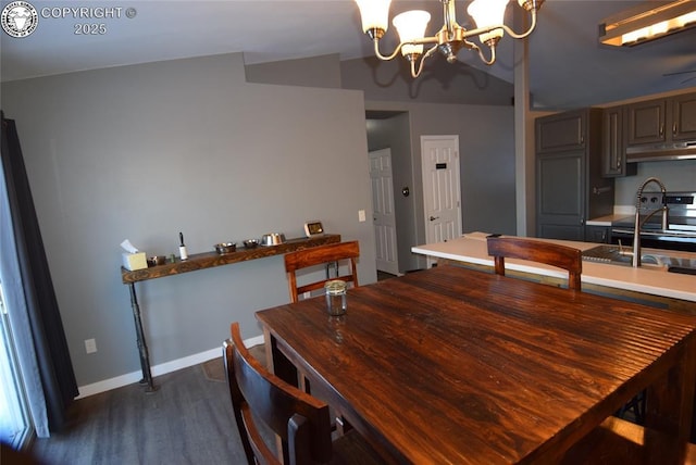 dining area featuring dark hardwood / wood-style flooring, a notable chandelier, lofted ceiling, and sink