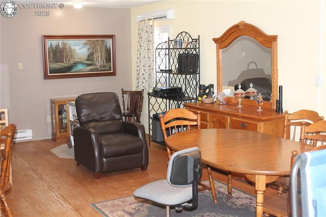 dining room with a baseboard heating unit and a wall mounted AC