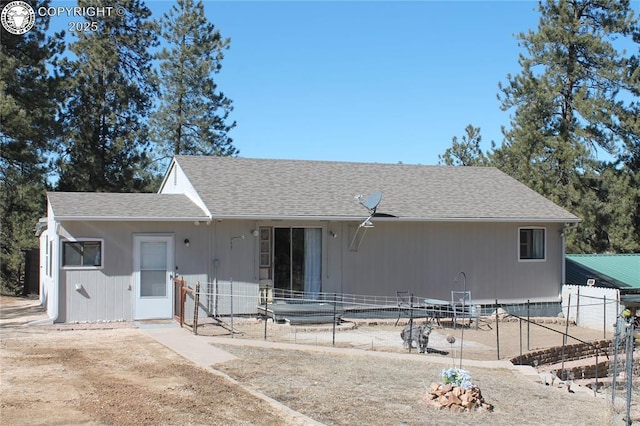 view of front of property with a patio area, fence, and roof with shingles