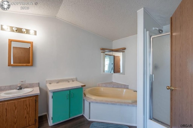 bathroom with vaulted ceiling, a textured ceiling, vanity, independent shower and bath, and hardwood / wood-style floors