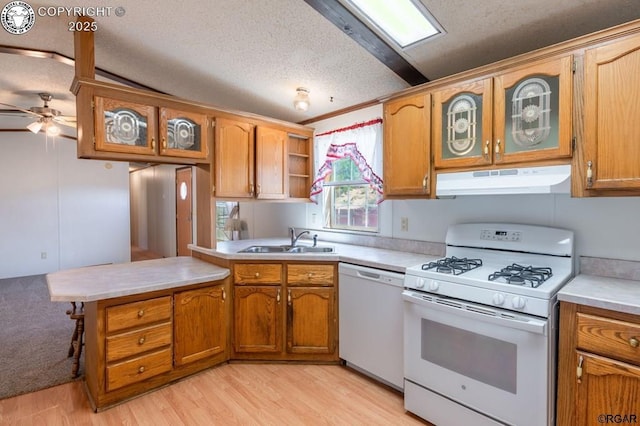 kitchen with sink, a textured ceiling, light wood-type flooring, kitchen peninsula, and white appliances