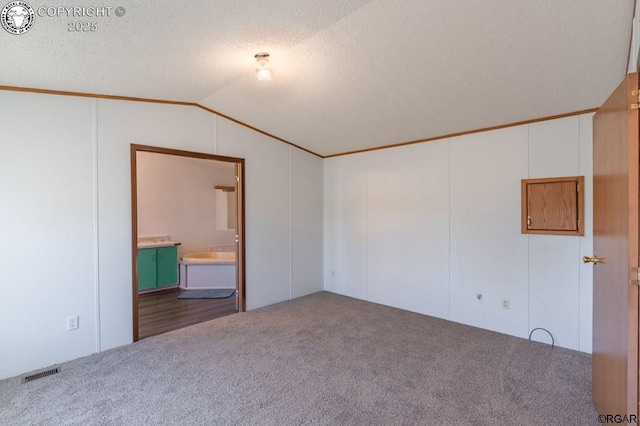 carpeted spare room with vaulted ceiling