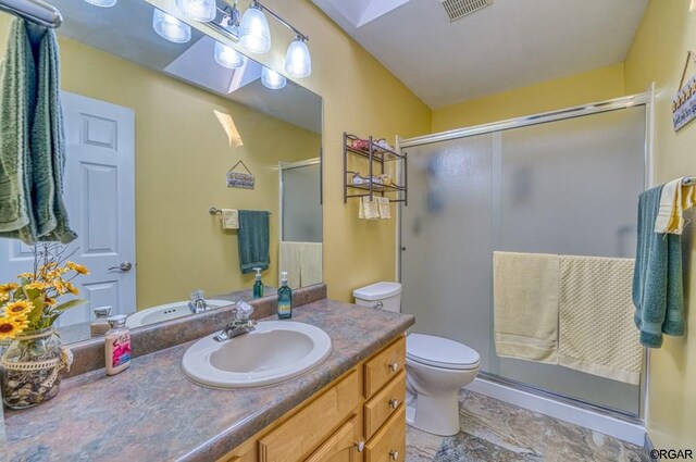 bathroom with vanity, a shower with shower door, and toilet