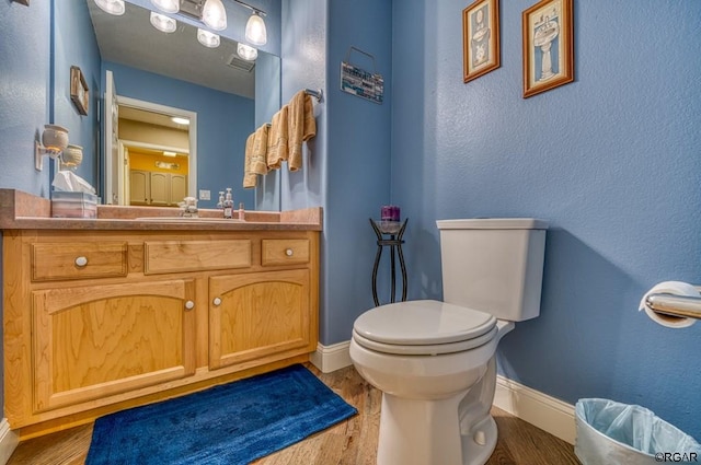 bathroom featuring hardwood / wood-style flooring, vanity, and toilet