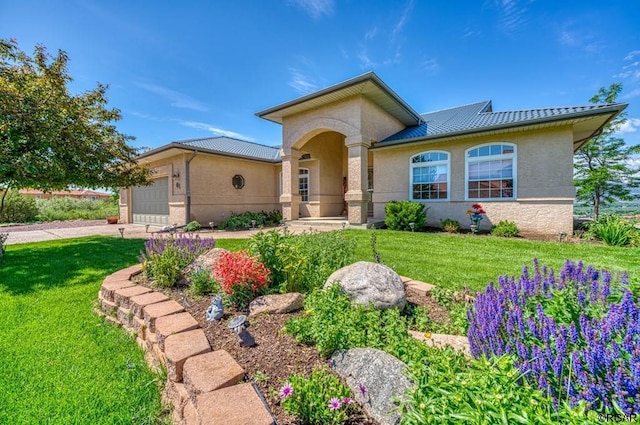 view of front of property featuring stucco siding, driveway, a front lawn, and an attached garage