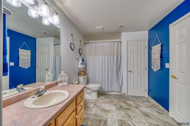 bathroom featuring a shower with curtain, vanity, toilet, and a textured ceiling