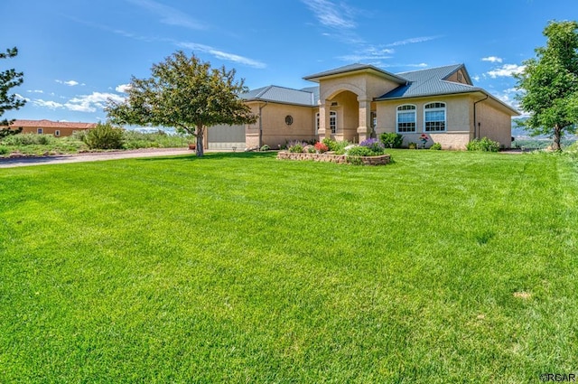 mediterranean / spanish-style house with a front yard, an attached garage, driveway, and stucco siding