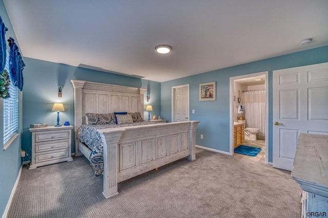 bedroom featuring ensuite bath and light carpet