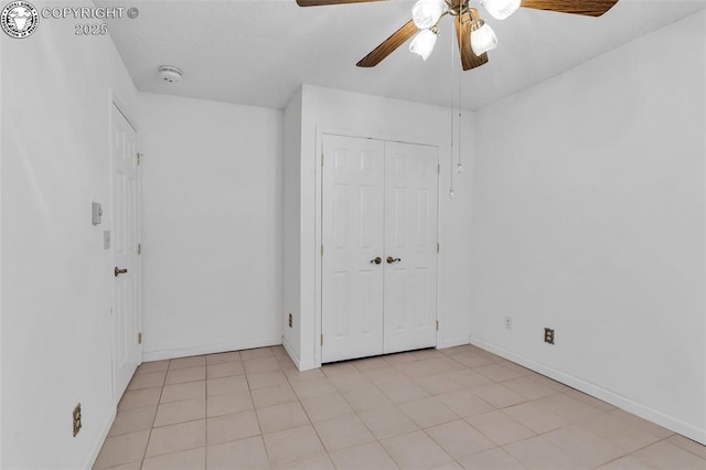 unfurnished bedroom featuring ceiling fan, a closet, and light tile patterned floors