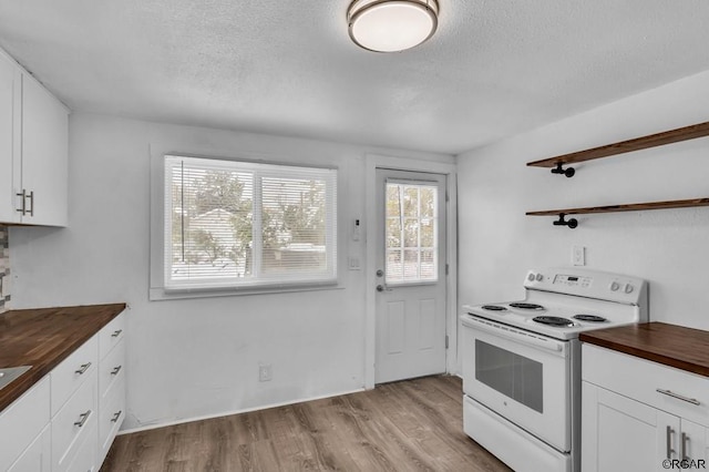 kitchen featuring white cabinets, light hardwood / wood-style floors, butcher block countertops, and electric range