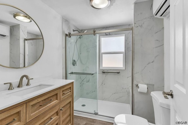 bathroom featuring an enclosed shower, vanity, toilet, and a wall mounted AC