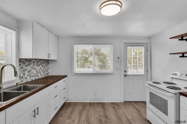 kitchen with white electric range, sink, white cabinets, decorative backsplash, and plenty of natural light