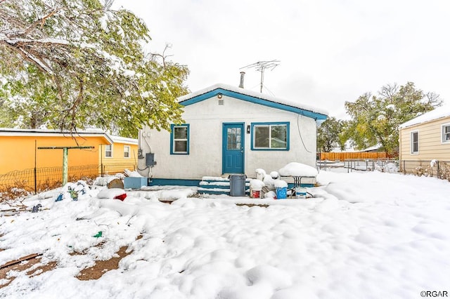 view of snow covered back of property