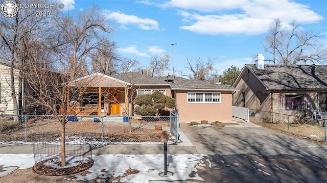 view of front facade featuring stucco siding and a fenced front yard