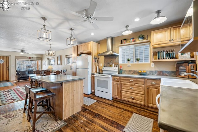 kitchen with dark wood-style floors, a sink, wall chimney range hood, a kitchen island, and white appliances