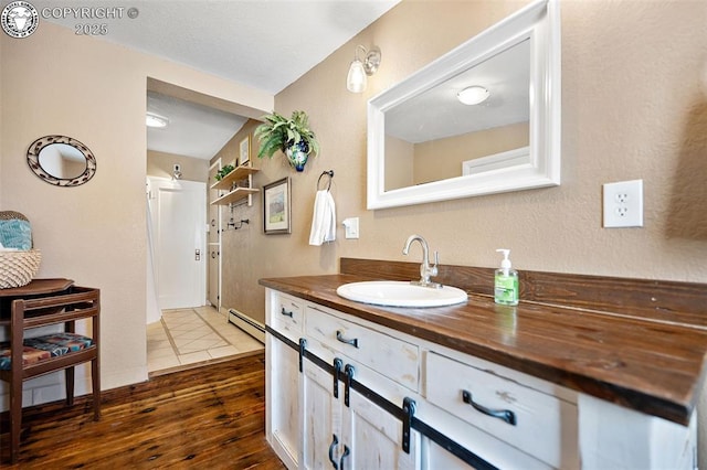 bathroom featuring a baseboard radiator, vanity, and wood finished floors