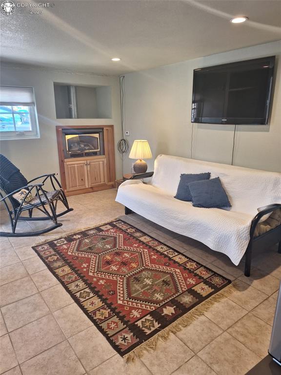 living area featuring a fireplace, recessed lighting, and light tile patterned floors