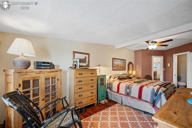 bedroom with dark wood-style floors, beam ceiling, a textured ceiling, and a ceiling fan