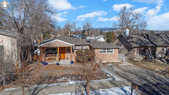 ranch-style house featuring driveway, fence, and covered porch