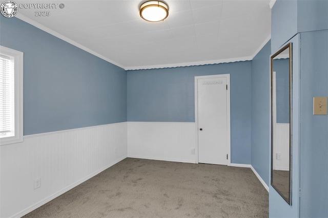 unfurnished room with ornamental molding and light colored carpet