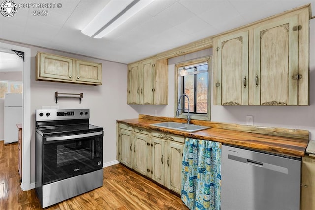 kitchen featuring wood counters, stainless steel appliances, sink, and light wood-type flooring