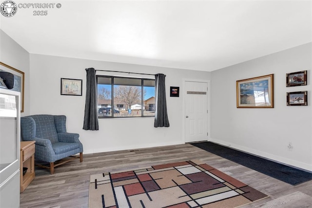 sitting room with baseboards and wood finished floors