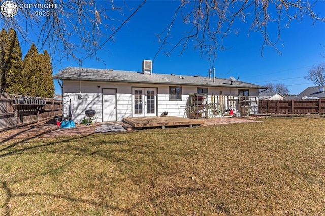 back of property featuring a yard, french doors, and a fenced backyard