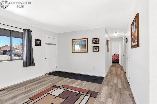 interior space featuring visible vents, baseboards, and wood finished floors