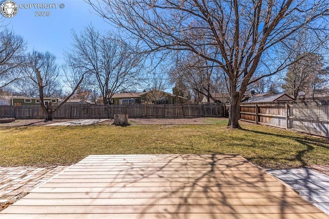 wooden deck with a fenced backyard and a lawn