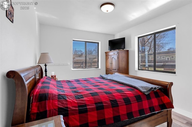 bedroom featuring baseboards and wood finished floors