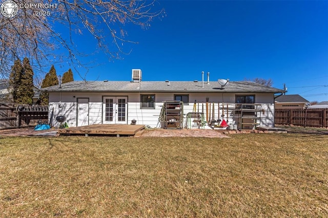 back of property featuring fence private yard, a yard, a deck, and french doors