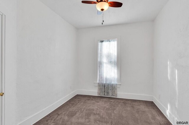 carpeted spare room with ceiling fan