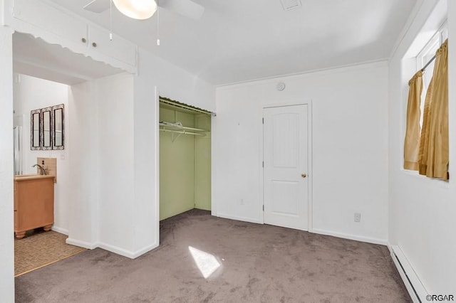 unfurnished bedroom with a baseboard radiator, ornamental molding, carpet floors, a closet, and ceiling fan