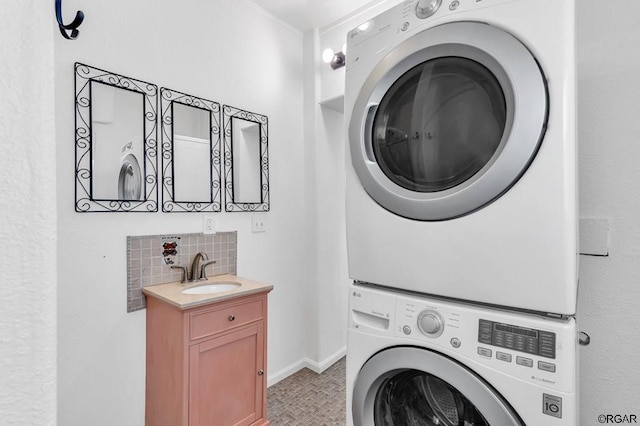 laundry area featuring stacked washer / drying machine, light tile patterned floors, and sink