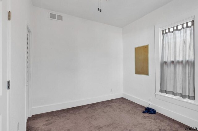 carpeted empty room featuring ceiling fan