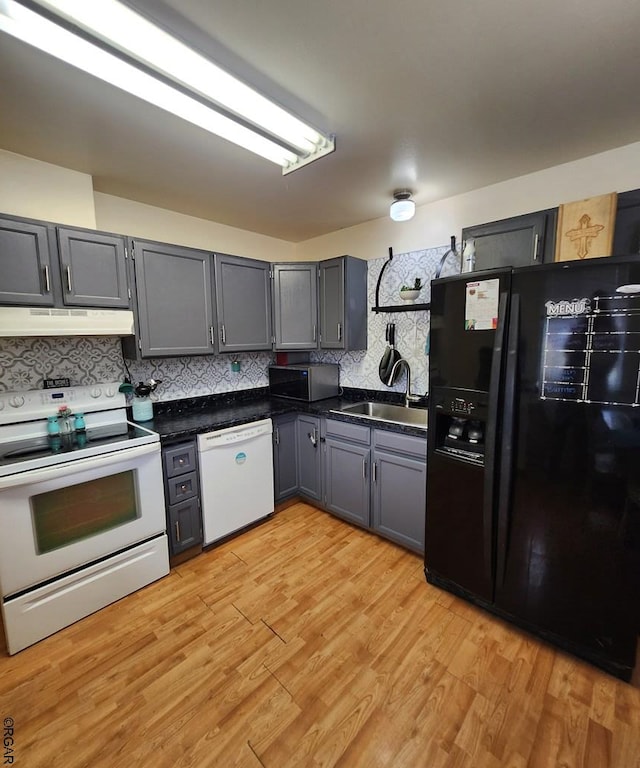 kitchen featuring white appliances, gray cabinets, sink, and light hardwood / wood-style flooring