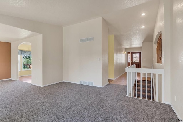 unfurnished room with light carpet and a textured ceiling