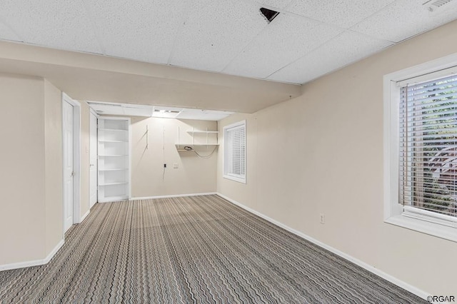 basement featuring carpet flooring and a drop ceiling