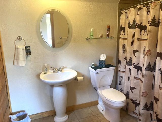 bathroom featuring tile patterned flooring, a shower with shower curtain, and toilet