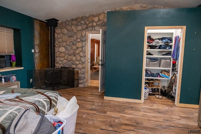 bedroom with hardwood / wood-style flooring and a wood stove