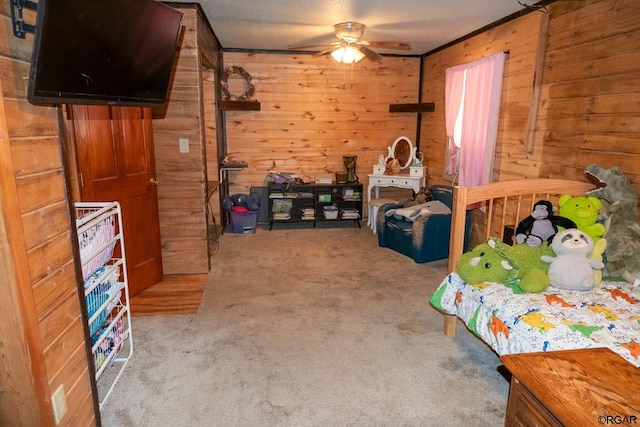 bedroom featuring ceiling fan, light colored carpet, a textured ceiling, and wood walls