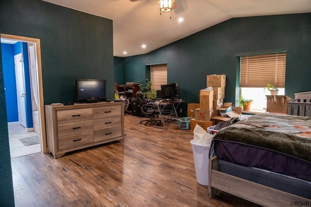 bedroom with lofted ceiling, hardwood / wood-style flooring, and ensuite bath