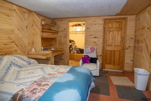 bedroom with a spacious closet, wooden walls, a closet, and a textured ceiling