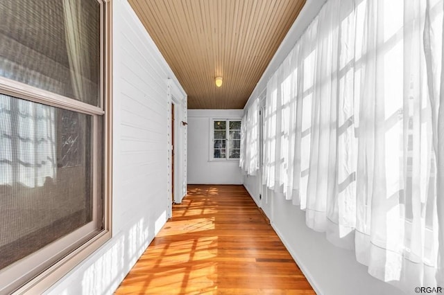 hall with light wood-style floors and wood ceiling