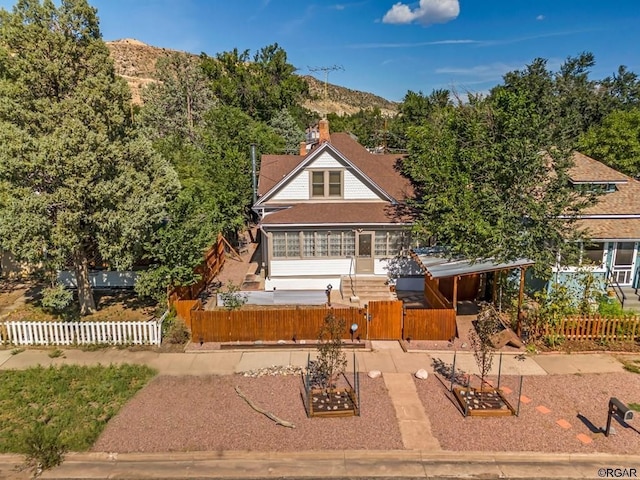 view of front of home with a fenced front yard, a gate, and a mountain view