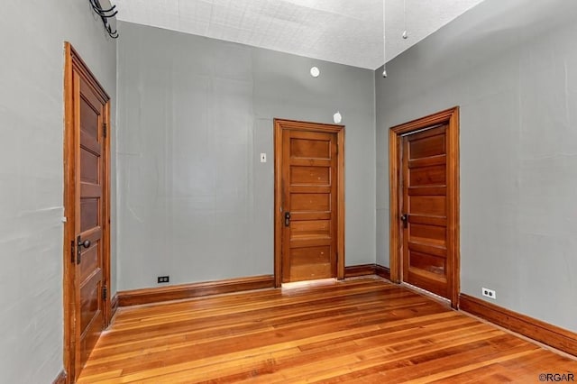 empty room featuring baseboards and light wood-style floors