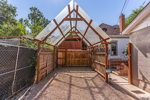 exterior space featuring a gate, fence, an exterior structure, and an outbuilding